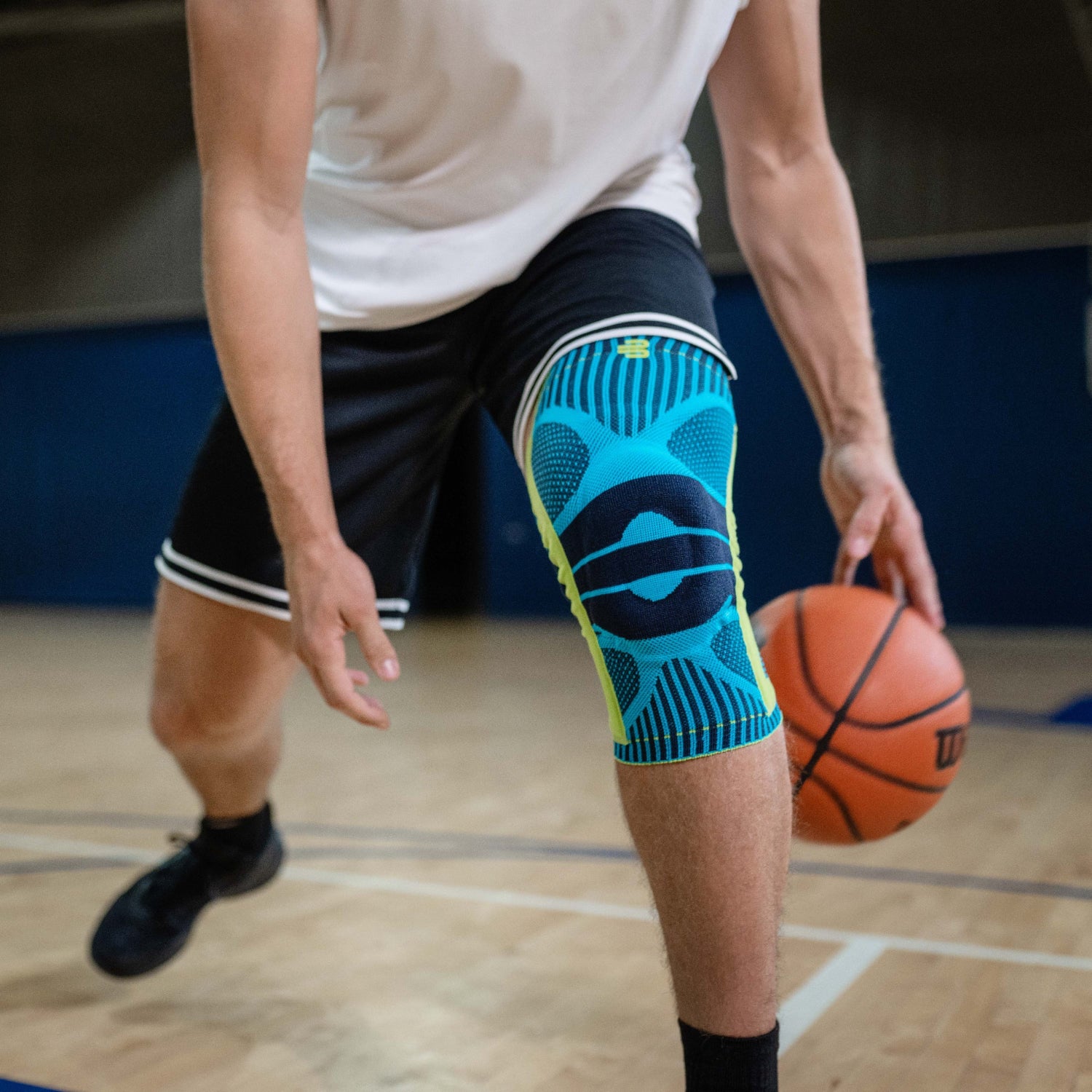 person playing basketball wearing Bauerfeind sports knee support